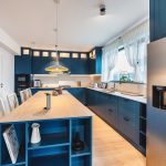 Bucătărie albastră clasică, cu insulă generoasă și dulapuri cu cercevea, vitrate iluminate, perfectă pentru un stil rafinat