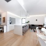 Bucătărie minimalistă albă cu insulă multifuncțională și spații de depozitare smart