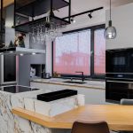Bucătărie deschisă cu insulă tip masă și mobilier mat, fără mânere, potrivită pentru familia modernă