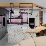 Bucătărie deschisă cu insulă tip masă și mobilier mat, fără mânere, potrivită pentru familia modernă